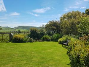 a park bench sitting in a field of grass at Hendy in Llanfaelrhys +11 photos