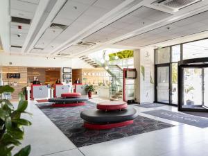 a lobby with two stools in the middle of a building at Novotel Sofia in Sofia