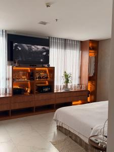 a bedroom with a large television and a bed at Flat Innerbloom Manaus in Manaus
