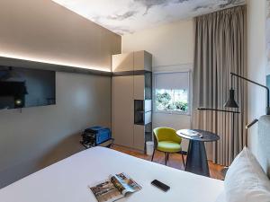 a hotel room with a bed and a table and a chair at Hotel Ibis Lisboa Parque das Nações in Lisbon +100 photos