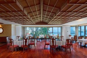 a dining room with white tables and chairs and windows at Montien Riverside Hotel Bangkok in Bangkok