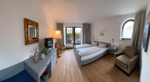 a bedroom with a bed and a couch and a chair at Hotel Bihler in Bad Aibling