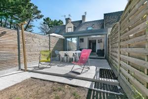 a patio with chairs and a table and a fence at Maisonnette de la mer Batz sur mer in Batz-sur-Mer