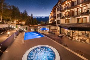 a view of a building with a swimming pool at night at SPA Resort St Ivan Rilski - Halfboard & All Inclusive in Bansko