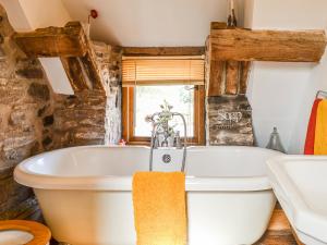 a bathroom with a white tub and a sink at Ty Fferm Hen - Uk36420 in Talybont