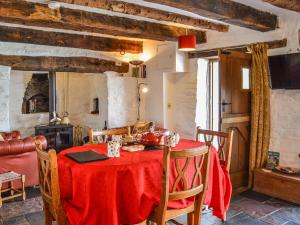 a dining room with a red table and chairs at Ty Fferm Hen - Uk36420 in Talybont