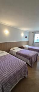 two beds in a hotel room with purple sheets at Ecopousada Miriti in Belém +102 photos