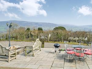 a patio with chairs and a table and a grill at Ty Nofio - Uk36421 in Talybont