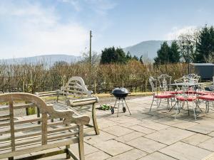 a patio with benches and a grill and a table and chairs at Ty Nofio - Uk36421 in Talybont