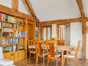 a dining room with a table and chairs and bookshelves at Ty Nofio - Uk36421 in Talybont