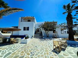a resort with white buildings and a palm tree at Coralli Beach Apartments in Mikri Vigla