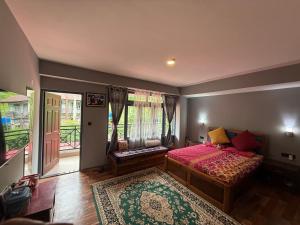 a bedroom with a bed and a balcony at Darap Dzimkha in Pelling
