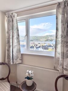 a room with two windows with curtains and a table at Broadlands View in Shaldon