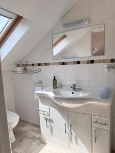 a white bathroom with a sink and a toilet at Broadlands View in Shaldon +63 photos