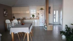 a kitchen with a table and a white refrigerator at Wind Rose Apartments Sumartin in Sumartin
