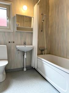 a bathroom with a sink and a tub and a toilet at Lägenhet Centrum Karlshamn in Karlshamn