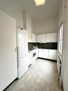 a kitchen with white cabinets and a white refrigerator at Lägenhet Centrum Karlshamn in Karlshamn