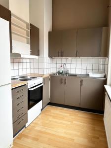 a kitchen with wooden floors and stainless steel appliances at Lägenhet Centrum Karlshamn in Karlshamn