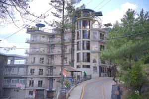 a large white building on the side of a street at Burj A Zafar in Murree