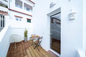 a room with a balcony with a table and chairs at Casa do Vento in Aljezur