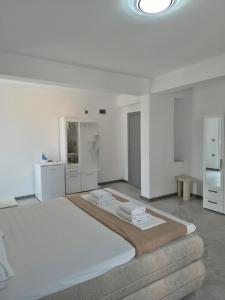 a large white bedroom with a large bed with white furniture at Silitur Keramoti in Keramoti
