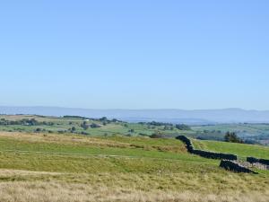 a field with a row of hay bales on a hill at Swallow's Nest - E3245 in Crackenthorpe
