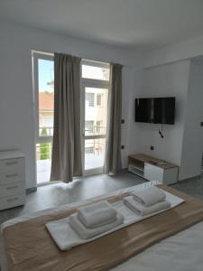 a white bedroom with a large bed with two white pillows at Silitur Keramoti in Keramoti
