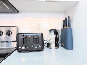 a black toaster sitting on a counter in a kitchen at Villa Meadows Lethbridge in Lethbridge