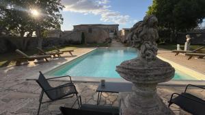 a pool with a statue in front of a building at Villa Castiglione 1863 - The real Sicilian holiday in Ragusa