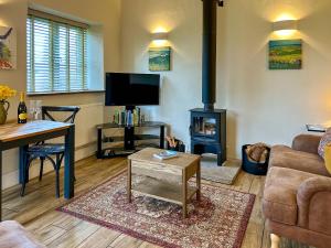 a living room with a wood stove in it at Blakeskerra Barn in Kenfig