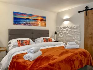 a bedroom with two beds with towels on them at Blakeskerra Barn in Kenfig