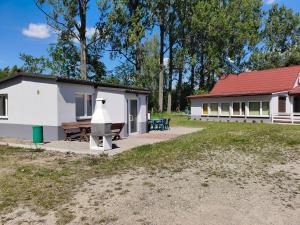 a white building with a picnic table and a house at Antares noclegi u Basi in Młoszowa