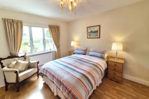 a bedroom with a bed and a chair and a window at Hook Head Guest House in Fethard on Sea