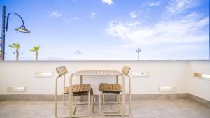 two chairs and a table in front of a wall at Solemar Sicilia - Casa Bella in Bagheria +9 photos