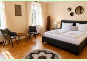 a bedroom with a large bed and two chairs at arte vida in Salzburg