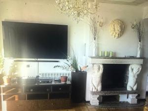 a living room with a fireplace with a large television at Villa Maya in Portorož