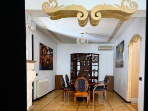 a dining room with chairs and a chandelier at Villa Maya in Portorož