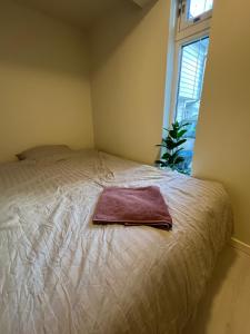 a bed with a towel on it in a room with a window at Harmony Apartments - Stavanger Sentrum 2 in Stavanger