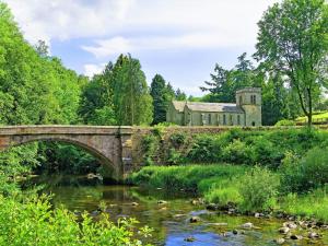 a bridge over a river with a building in the background at Cruck End - E3749 in Crackenthorpe