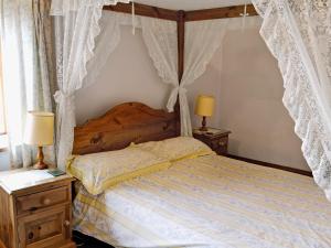 a bedroom with a canopy bed with drapes at Cruck End - E3749 in Crackenthorpe