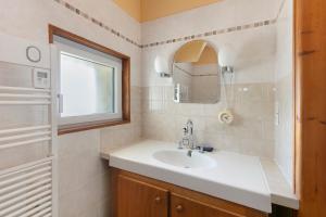 a bathroom with a sink and a mirror and a window at Villa Timao Plage in Batz-sur-Mer +23 photos