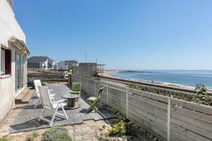a patio with chairs and a table and the ocean at Villa Timao Plage in Batz-sur-Mer