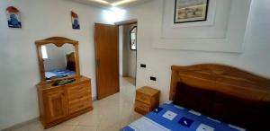 a bedroom with a bed and a dresser and a mirror at Casa ahlam in Chefchaouen