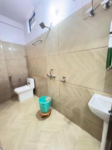 a bathroom with a toilet and a sink and a bucket at Hotel Ganpati place in Uttarkāshi +13 photos