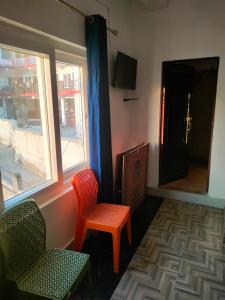 a waiting room with two chairs and a window at Hotel Ganpati place in Uttarkāshi