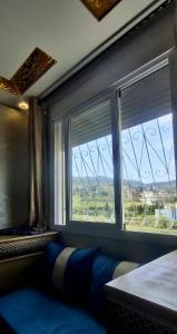 a room with a bed and a window with a view at Casa ahlam in Chefchaouen