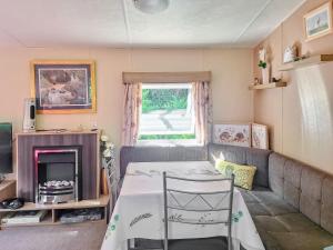 a small living room with a bed and a couch at Glen Y Nant in Llanfihangel-nant-Melan