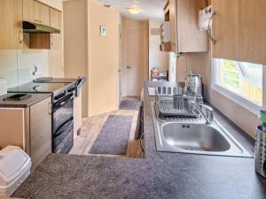 a small kitchen with a sink and a stove at Glen Y Nant in Llanfihangel-nant-Melan