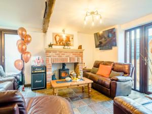 a living room with leather furniture and a fireplace at The Big Old Dairy in Weston-super-Mare