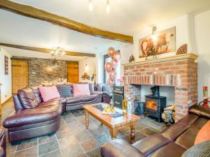 a living room with leather furniture and a fireplace at The Big Old Dairy in Weston-super-Mare